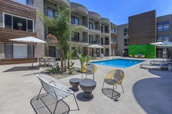 A pool area with a white chair and a yellow chair.